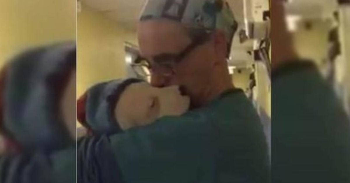 Veterinář po operaci kolébá vyděšené a plačící štěně záchranáře jako miminko